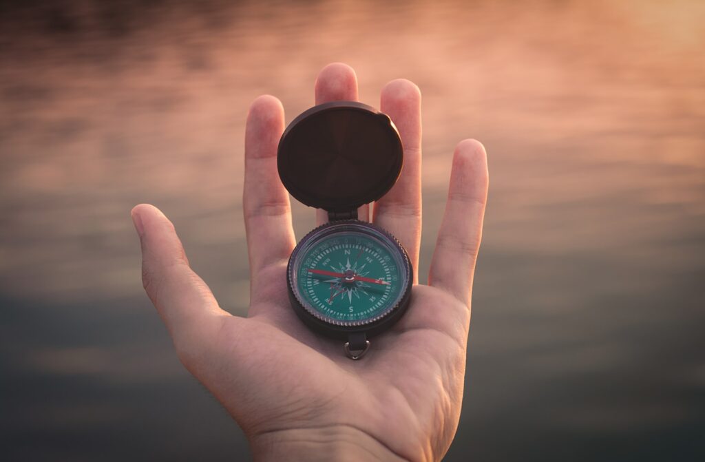 Photo of hand holding compass by Aron Visuals on Unsplash